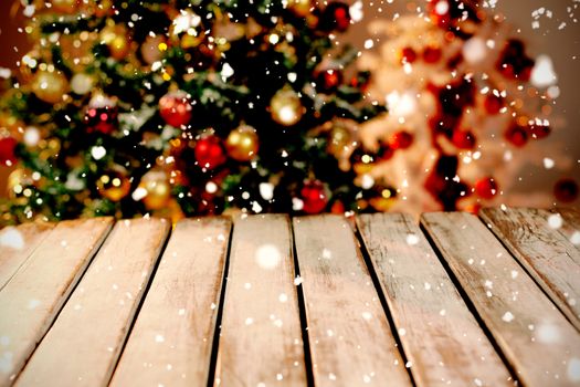 Snow falling against unfocused christmas tree with copy space