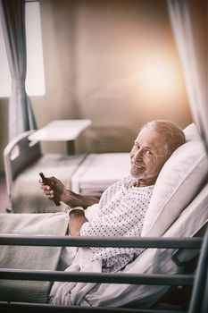 Patient watching television on bed in hospital