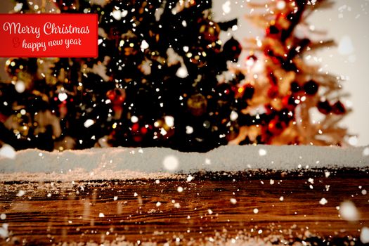 Banner Merry Christmas against wooden table with snow and unfocused christmas tree