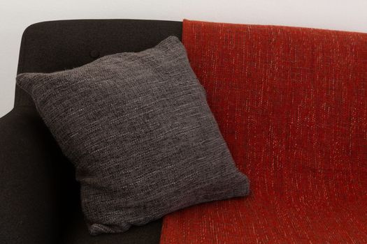 Close-up of cushion and blanket arranged on sofa