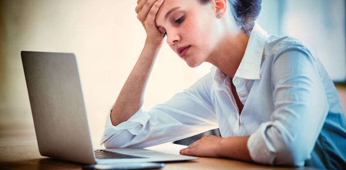 Tensed businesswoman using laptop in conference room 