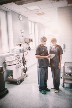 Surgeons discussing over digital tablet in a hospital