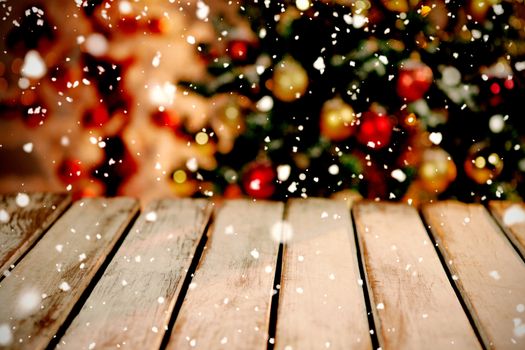 Snow falling against unfocused christmas tree with copy space