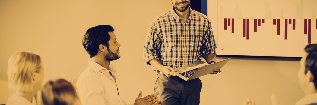 Coworkers applauding a colleague after presentation in the conference room