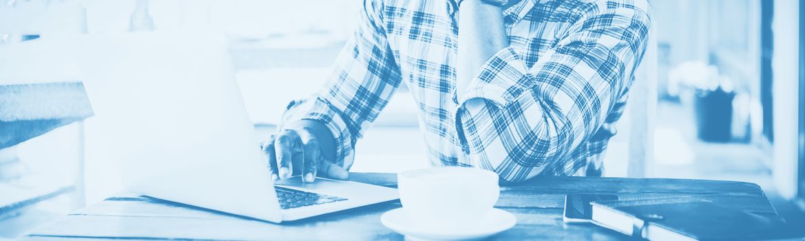 Man using laptop in cafeteria