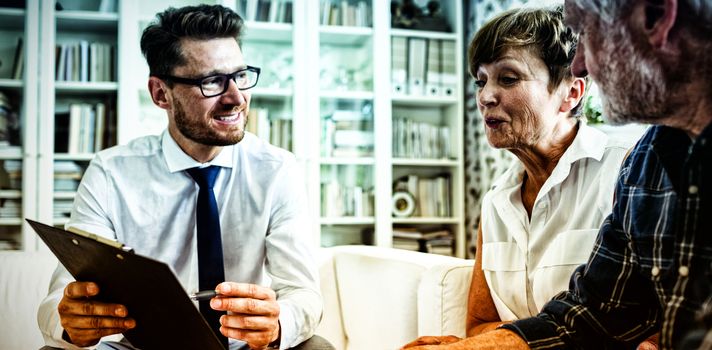 Senior couple planning their investments with financial advisor in living room