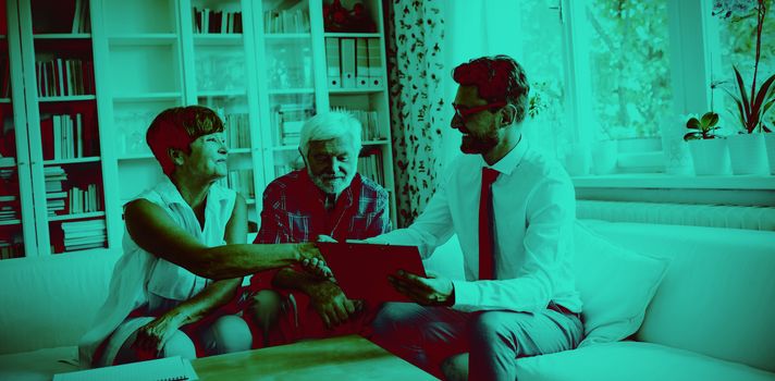 Financial advisor shaking hands with senior woman in living room