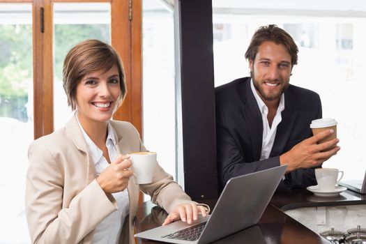 Business people smiling at the camera at the coffee shop