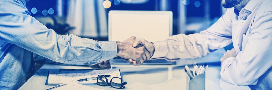 Businessmen shaking hands in conference room at office