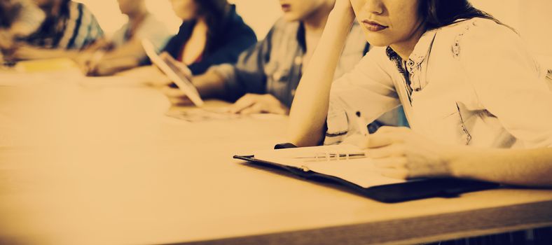 Bored woman sitting in meeting room with her colleagues