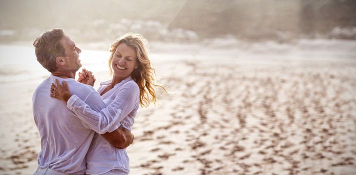 Happy mature couple having fun together at beach