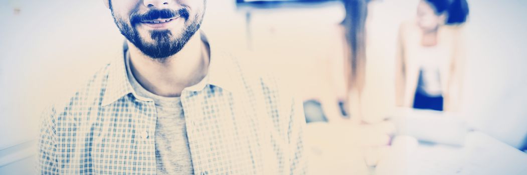 Portrait of confident young businessman standing in meeting room at creative office