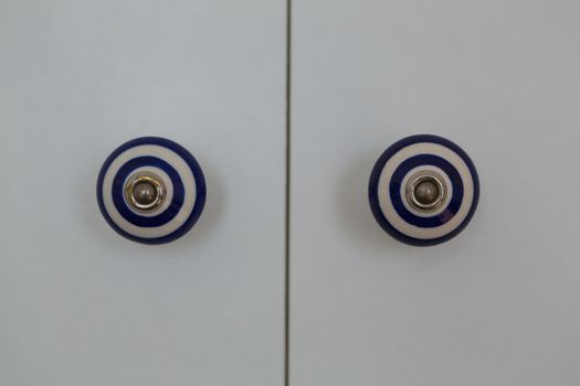 Front close-up view of a closed white modern door of cabinet at home