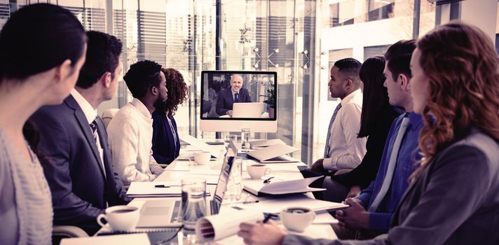 Focused business people looking at screen during video conference in office