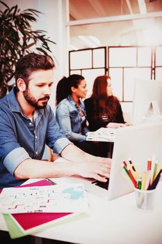 Creative business people using technologies at desk in creative office