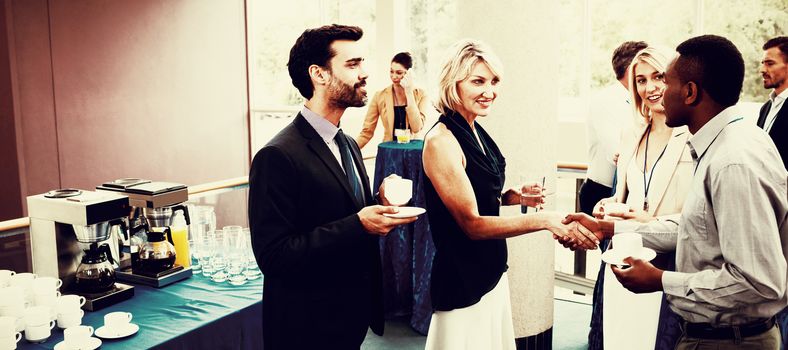 Business executives interacting with each other while having coffee at conference center