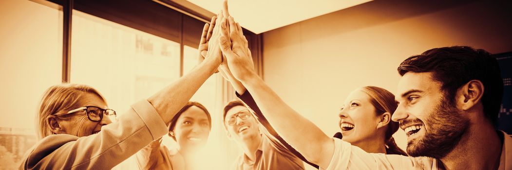 Business people giving high five at desk in the office