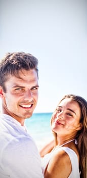 Portrait of cute couple embracing on the beach