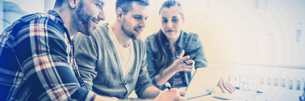 Young businessman discussing with colleagues during meeting in creative office