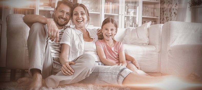 Happy family sitting on rug in living room at home