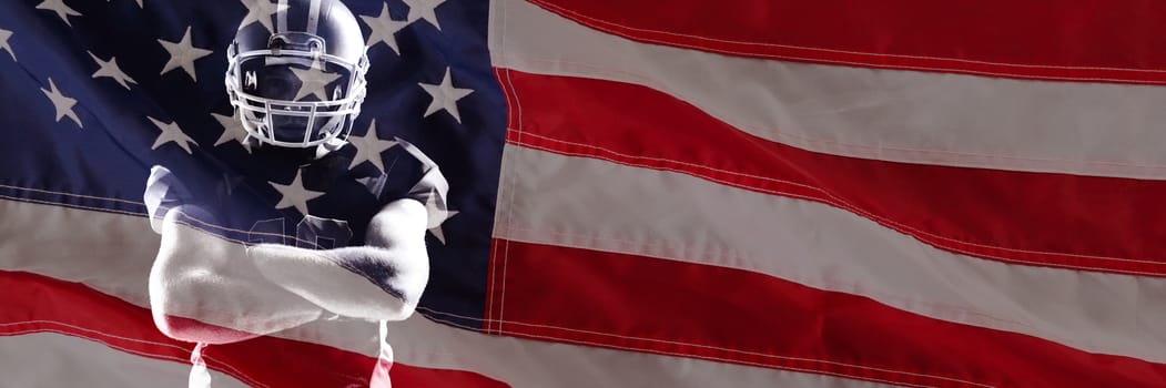 Close-up of an flag against american football player in helmet standing with arms crossed