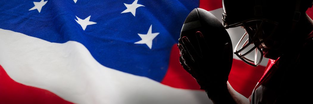 American football player standing with rugby helmet and ball against american flag with stars and stripes