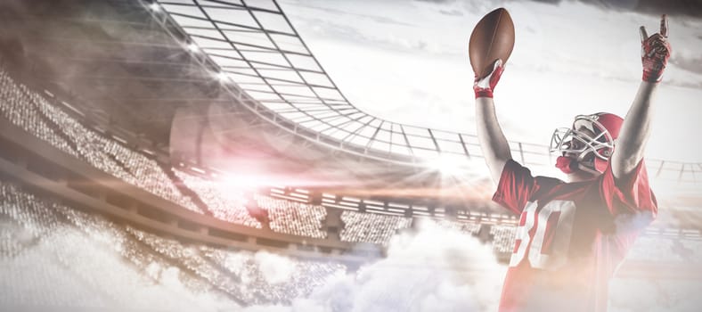 Young American football player standing with arms up