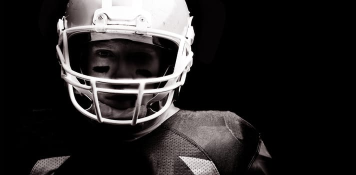 Close-up of American football player standing with rugby helmet