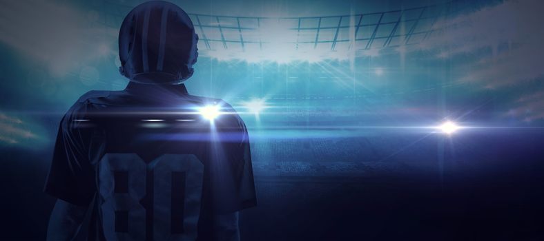 American football player standing in helmet against american football arena