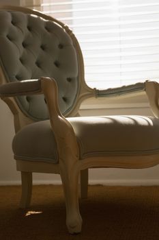 Close-up view of a luxury modern armchair placed in front of a sunny window at home