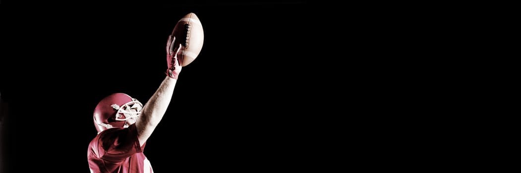 Side view of American football player cheering with arm up