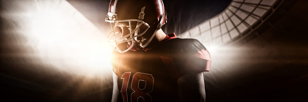 Young American football player standing in helmet