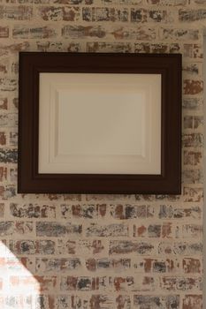 Front view of an empty picture frame fixed on the wall at home