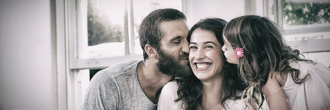 Happy mother receiving gift from her daughter and husband in living room