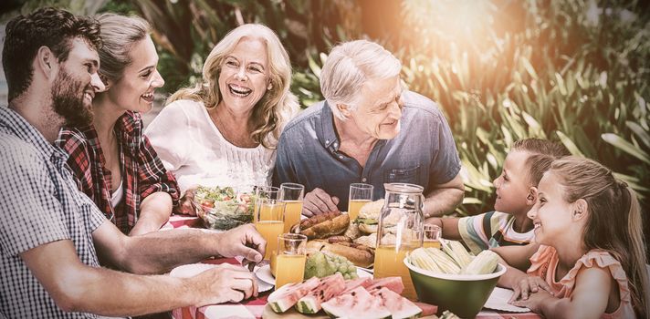 High angle view of family having food at table in yard 