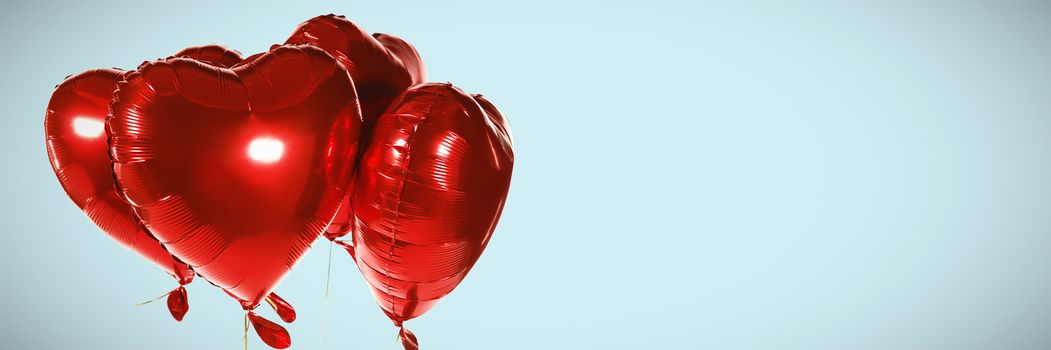 Red heart shape balloons against blue background