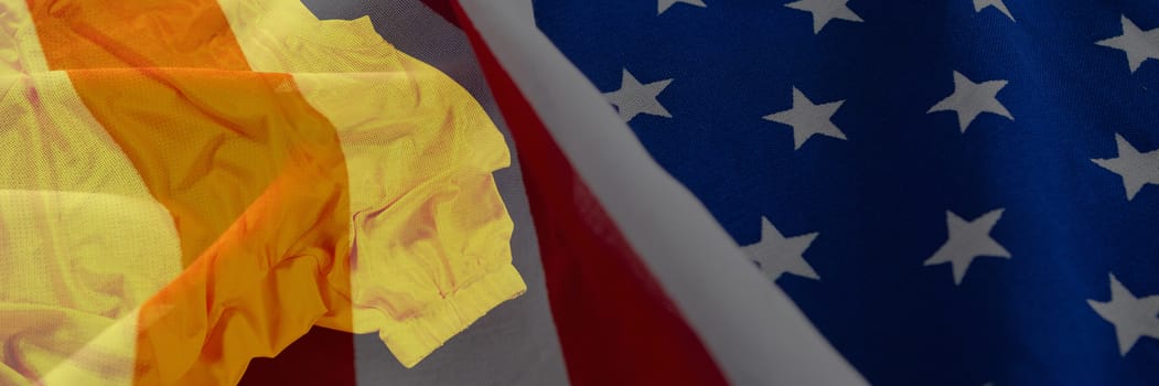 Close-up of crumbled American flag against rugby jersey against black background