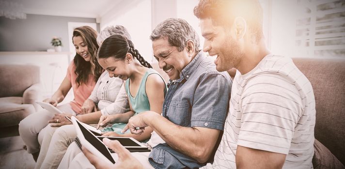 Multi-generation family using digital tablet in living room at home