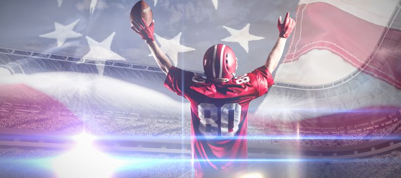 American football player in helmet holding rugby ball with arms in the air against full frame of american flag