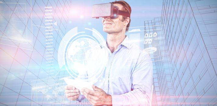 Businessman holding tablet while wearing vr glasses against composite image of technology interface 