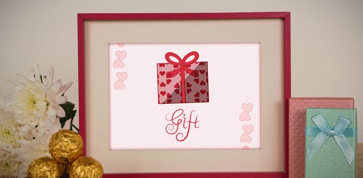 Cute Valentines Day message in Frame on desk with gifts and petals