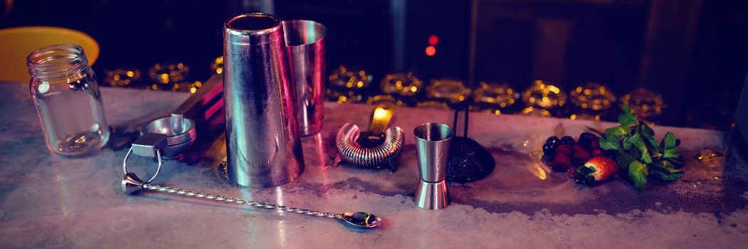 Bar accessories with cocktail ingredients on counter at bar