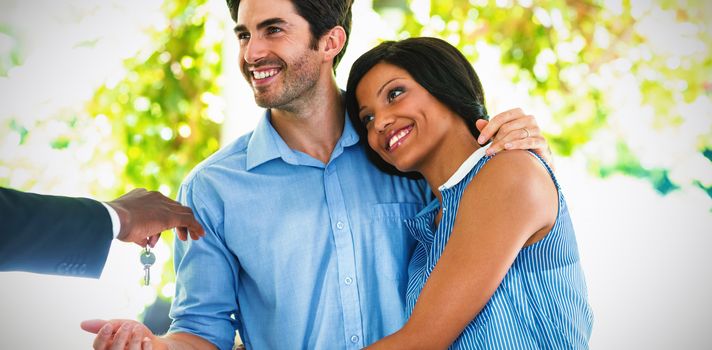 Real estate agent giving house keys to couple at home