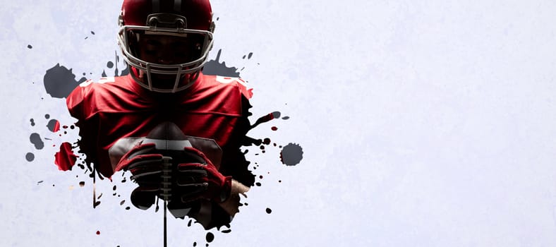 American football player standing with rugby helmet and ball against grey vignette