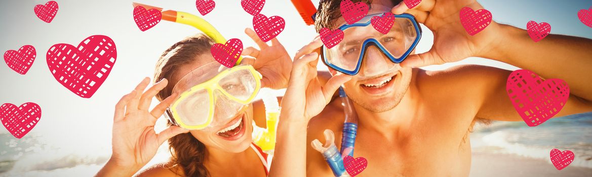 Red Hearts against couple posing with diving mask on beach