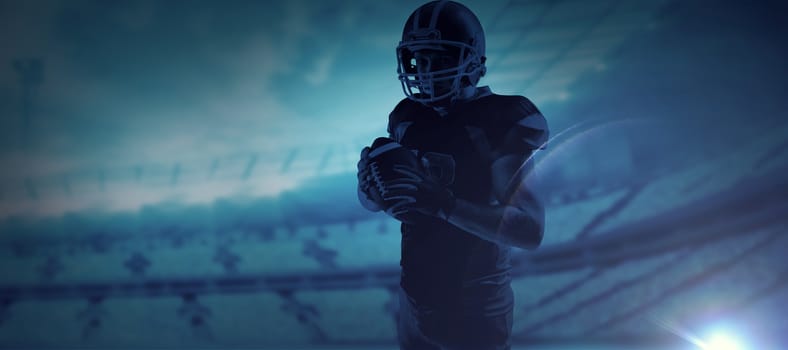 American football player in helmet holding rugby ball against rugby stadium