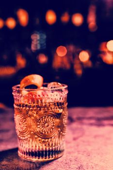 Close up of orange cocktail in glass at counter in bar
