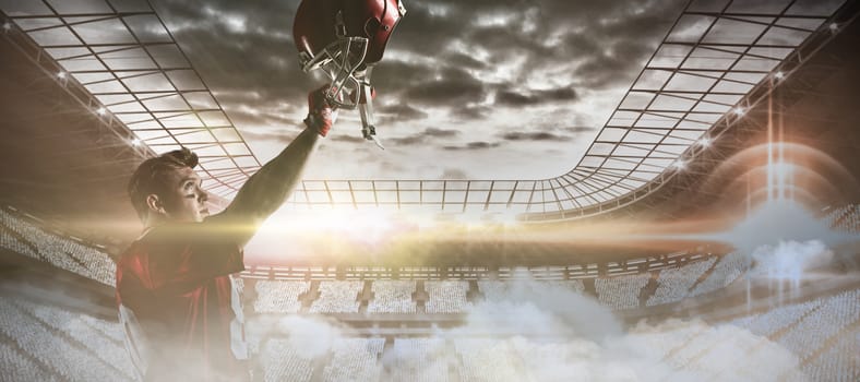 Young American football player cheering with hand raised