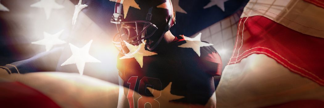 American football player standing in helmet against full frame of american flag