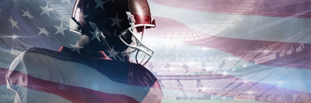 American football player in helmet looking off to the side against close-up of an american flag